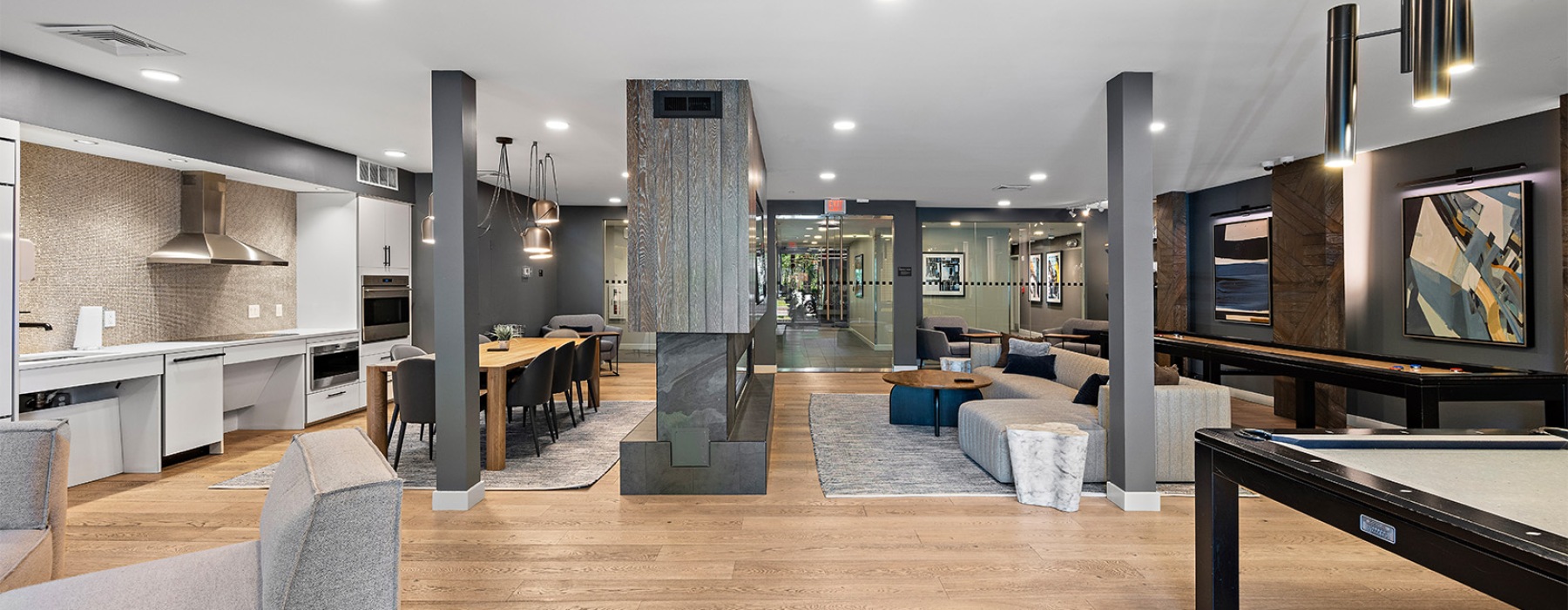 a room with couches, a tv, shuffleboard and a pool table